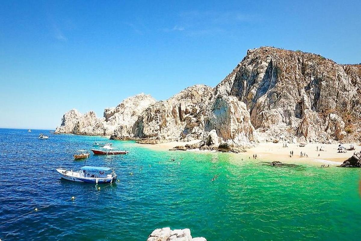 o plajă cu bărci în apă și oameni pe plajă