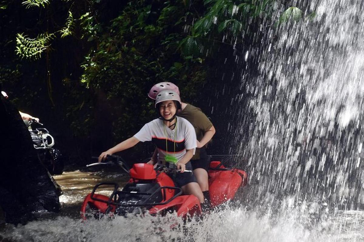 um menino andando de bicicleta aquática sob uma cachoeira