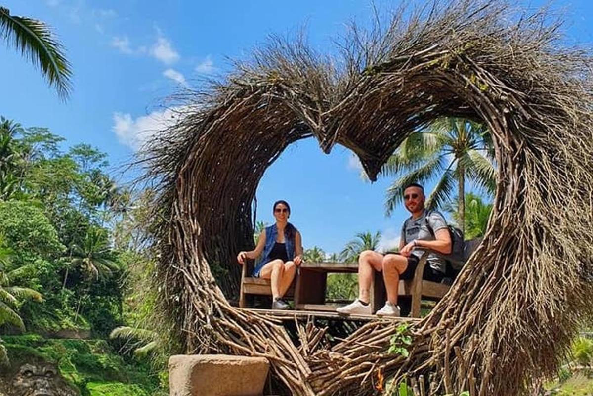 um homem e uma mulher sentados em um coração feito de grama