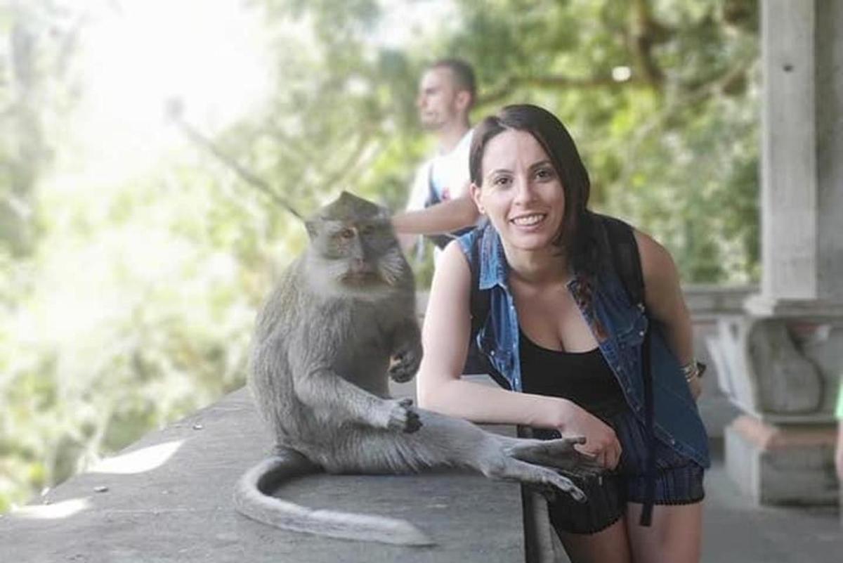 žena držící kočku sedící na stole