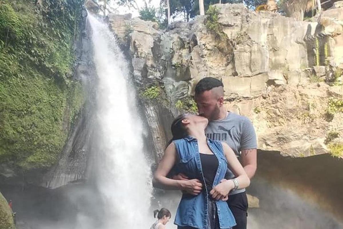 muž a žena stojící před vodopádem