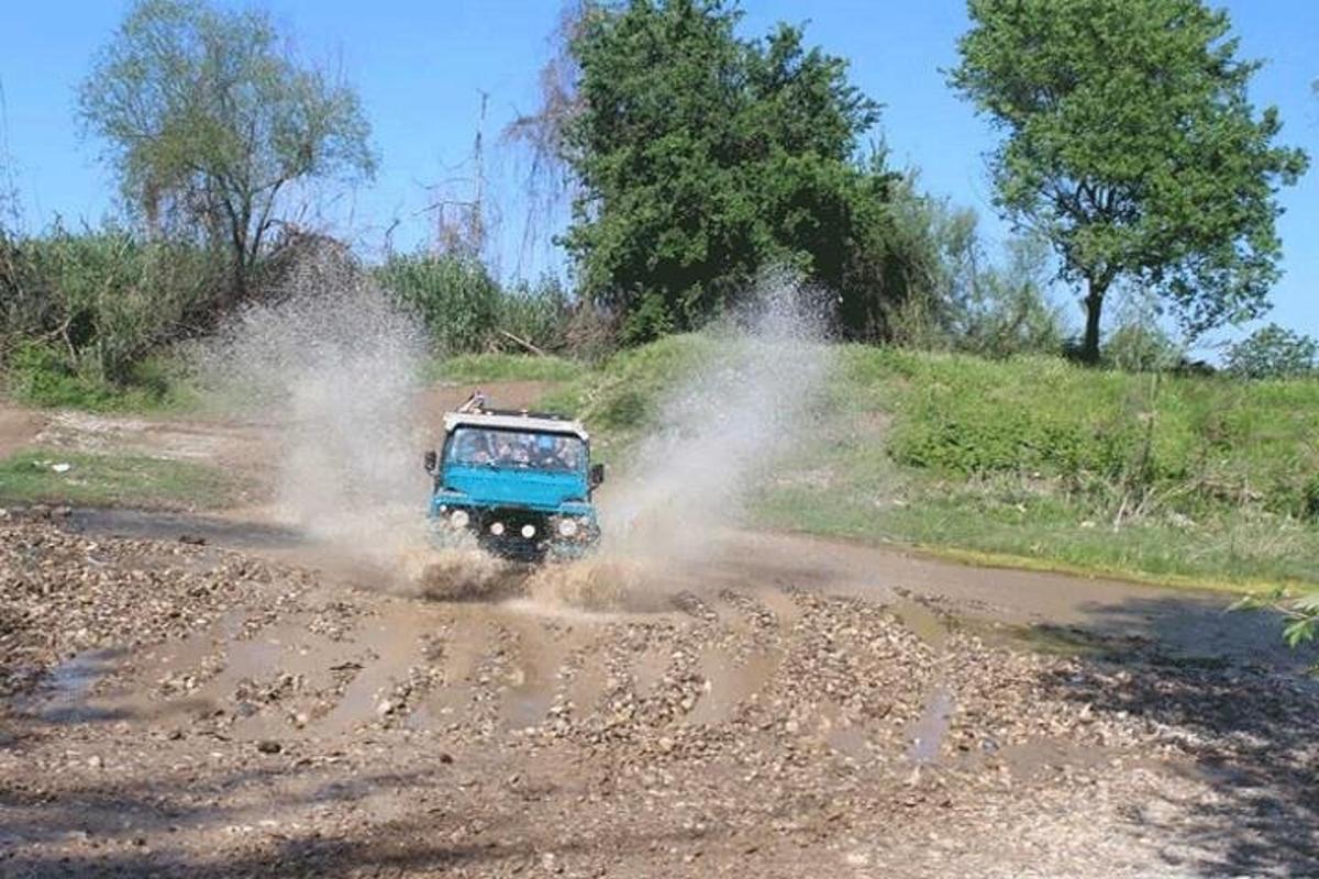a blue truck driving on a dirt road