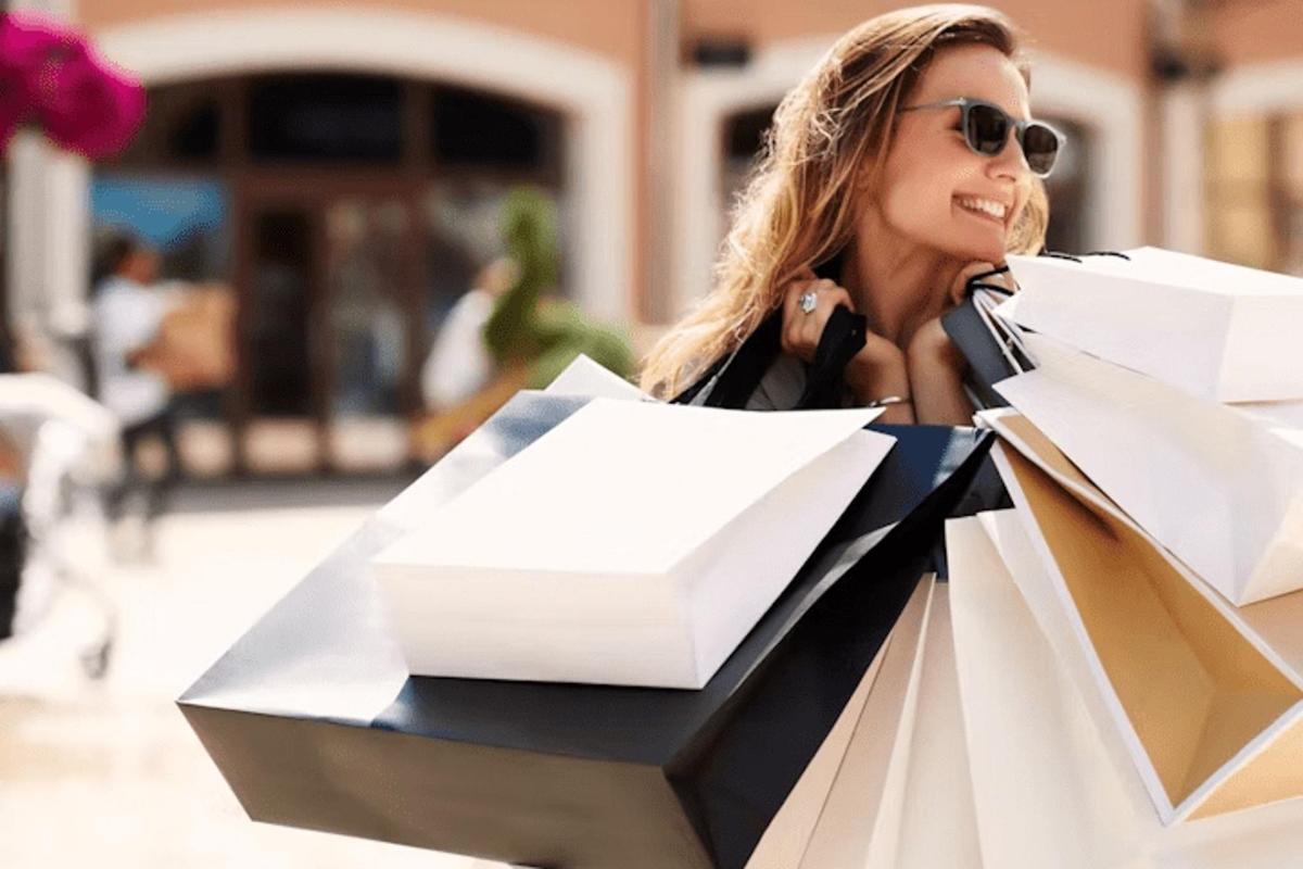 a woman holding a pile of papers in a shopping bag