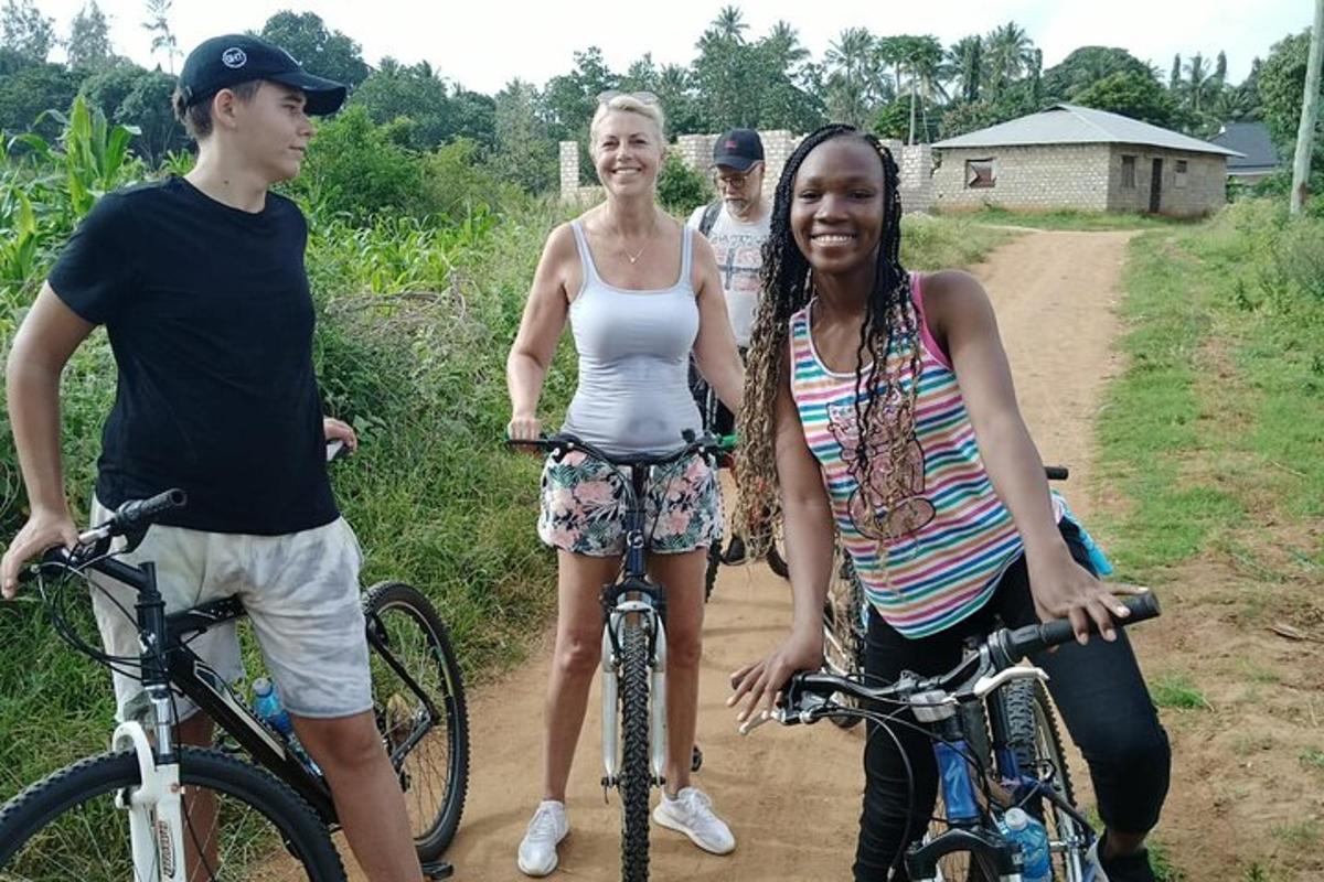 a group of people standing with bikes on a dirt road