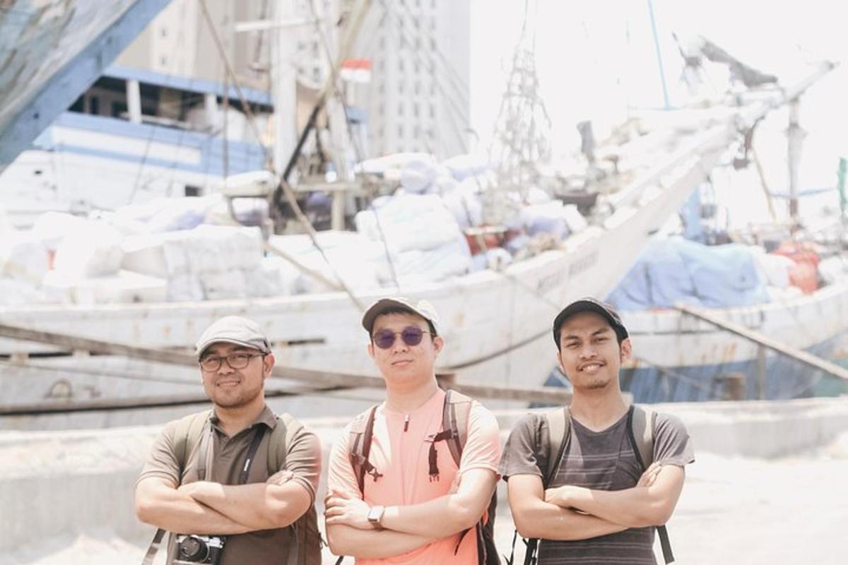 tatlong lalaking nakatayo habang nakakrus ang mga braso sa harap ng isang bangka