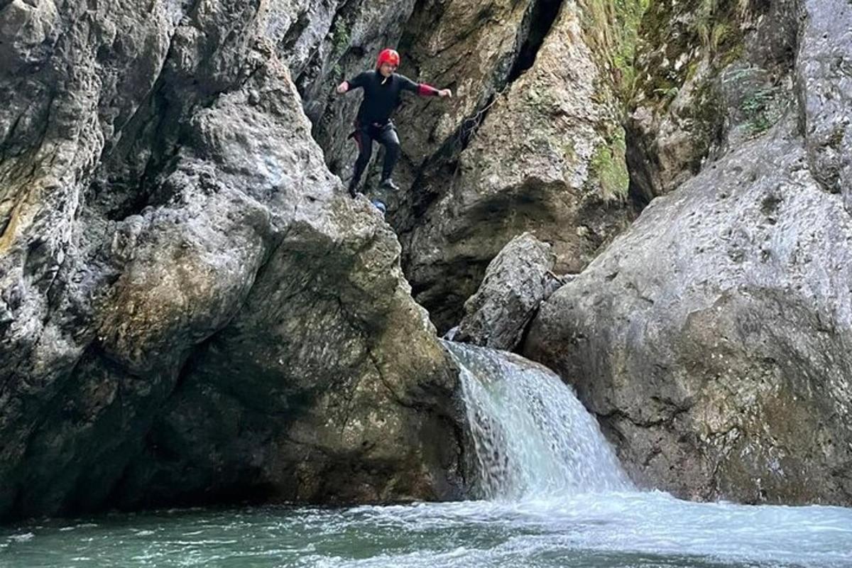 eine Person, die von einem Felsen in einen Wasserfall springt