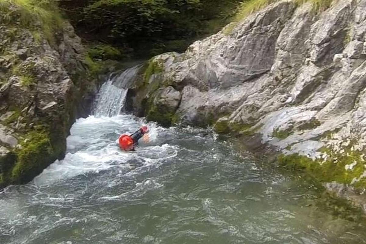 osoba na voru v řece vedle vodopádu