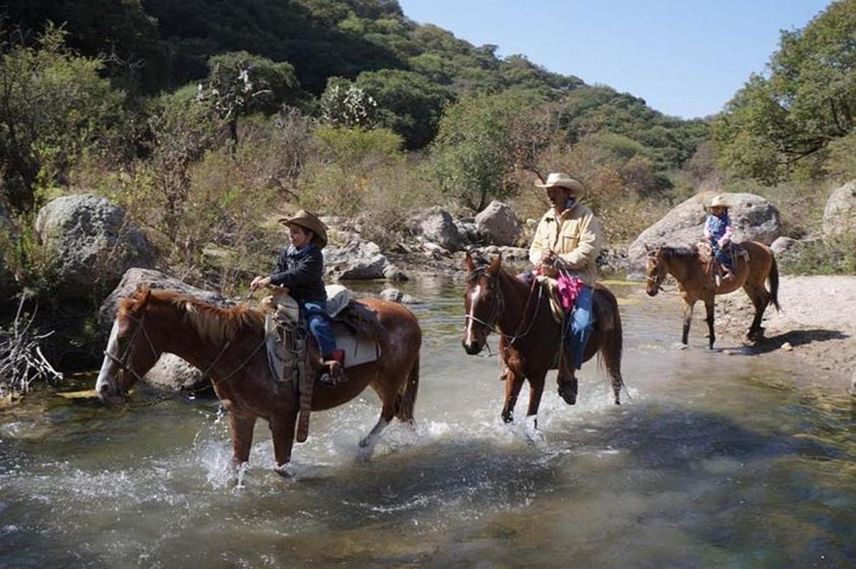 un gruppo di persone a cavallo attraverso un fiume