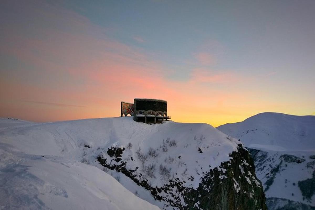 un edificio in cima a una montagna coperta di neve
