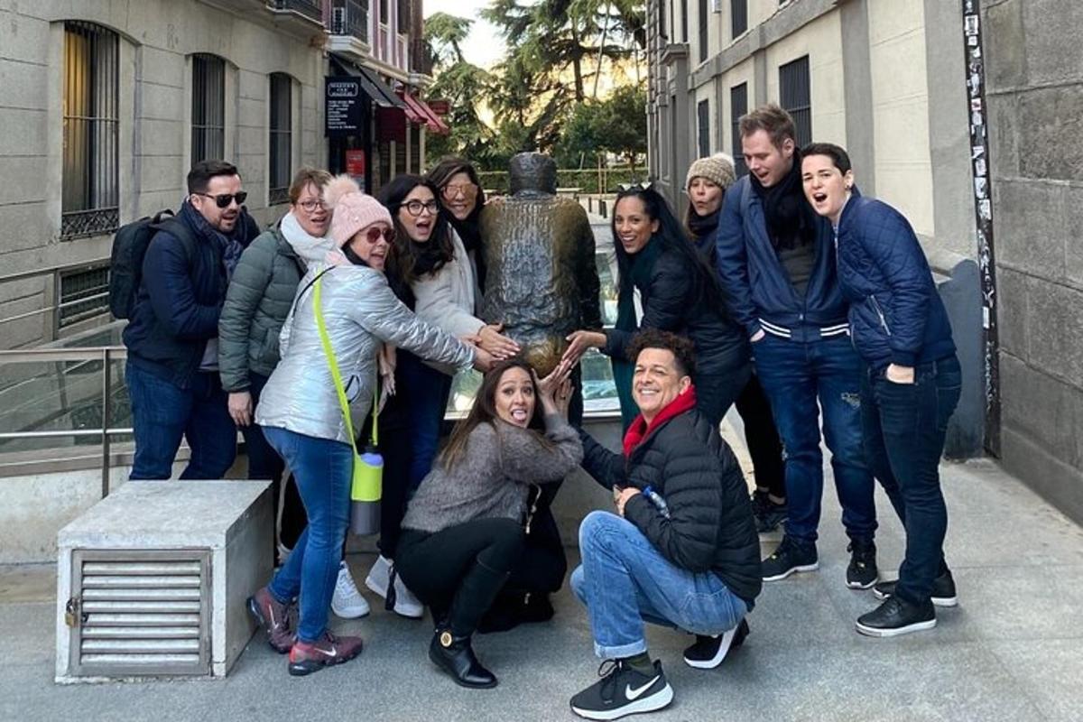a group of people posing in front of a statue