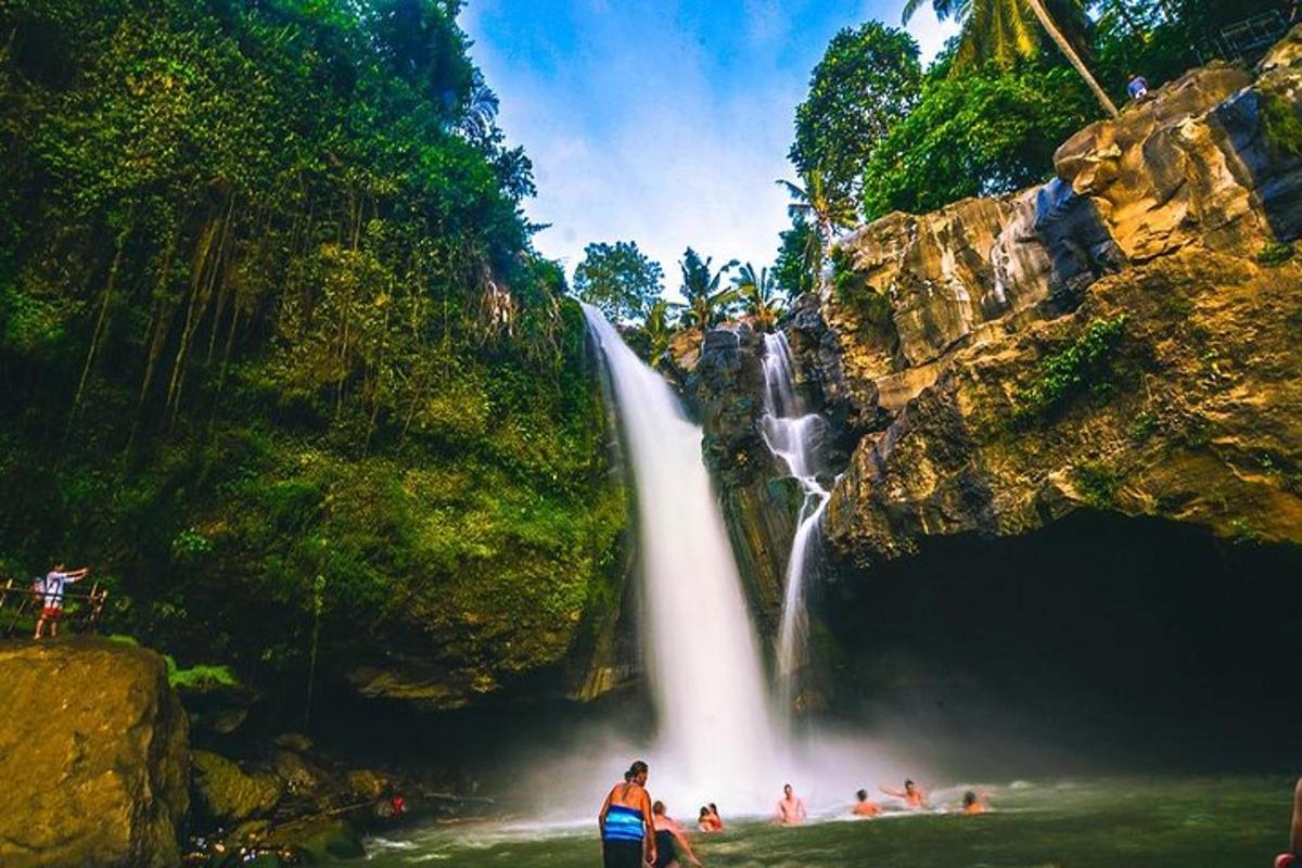 eine Gruppe von Menschen steht vor einem Wasserfall