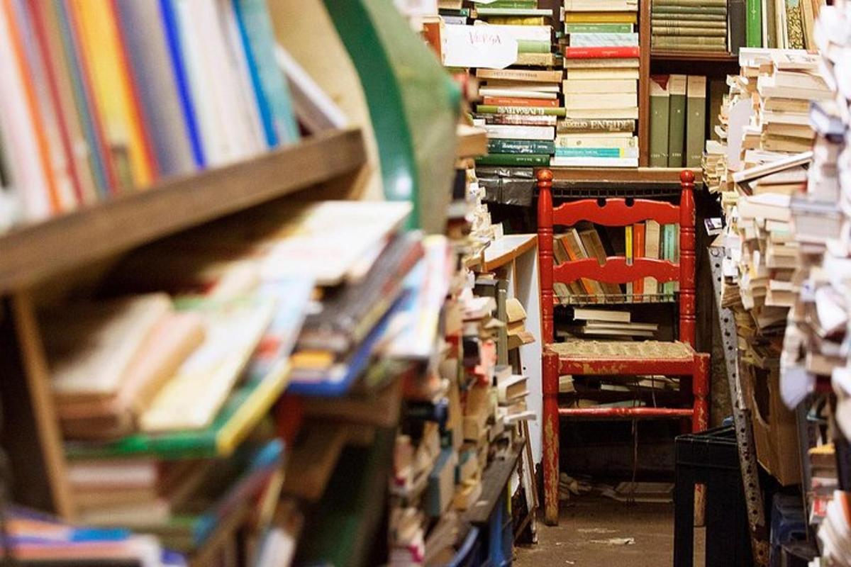 tumpukan buku di perpustakaan dengan kursi merah