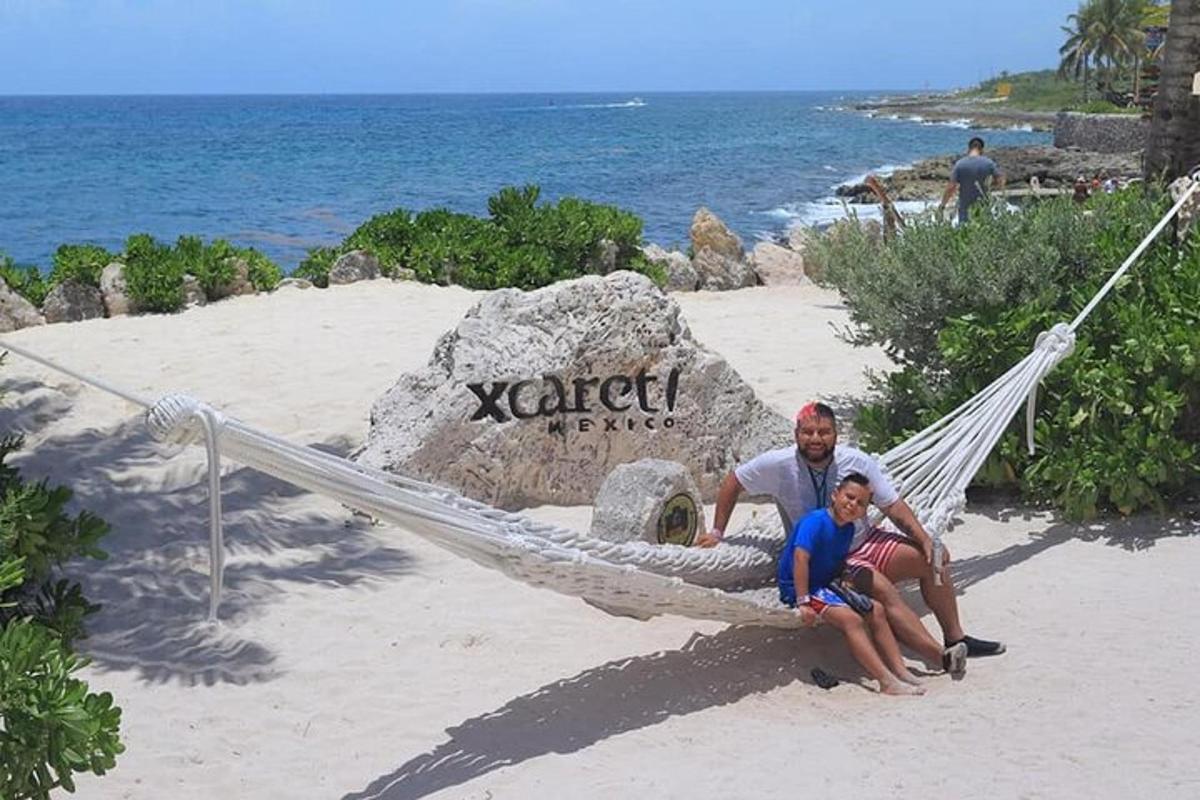 moški in otrok sedita v viseči mreži na plaži