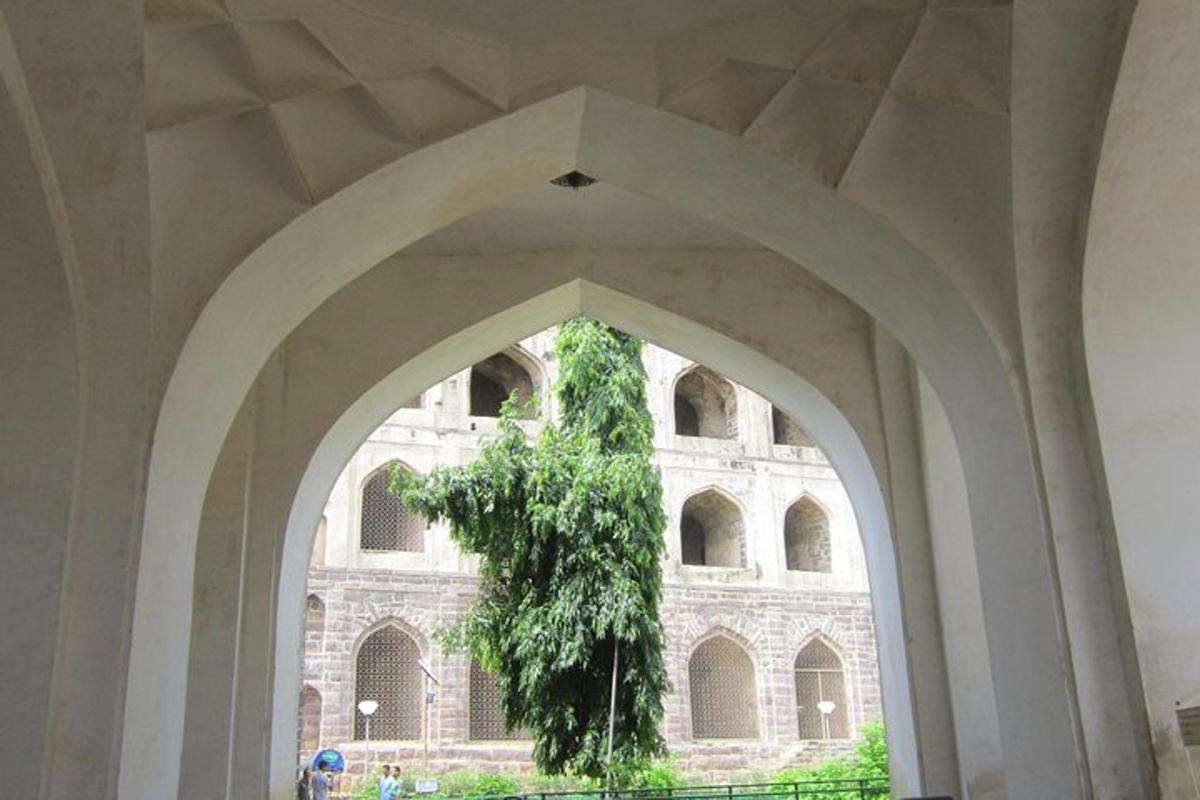 an archway with a plant hanging from a building