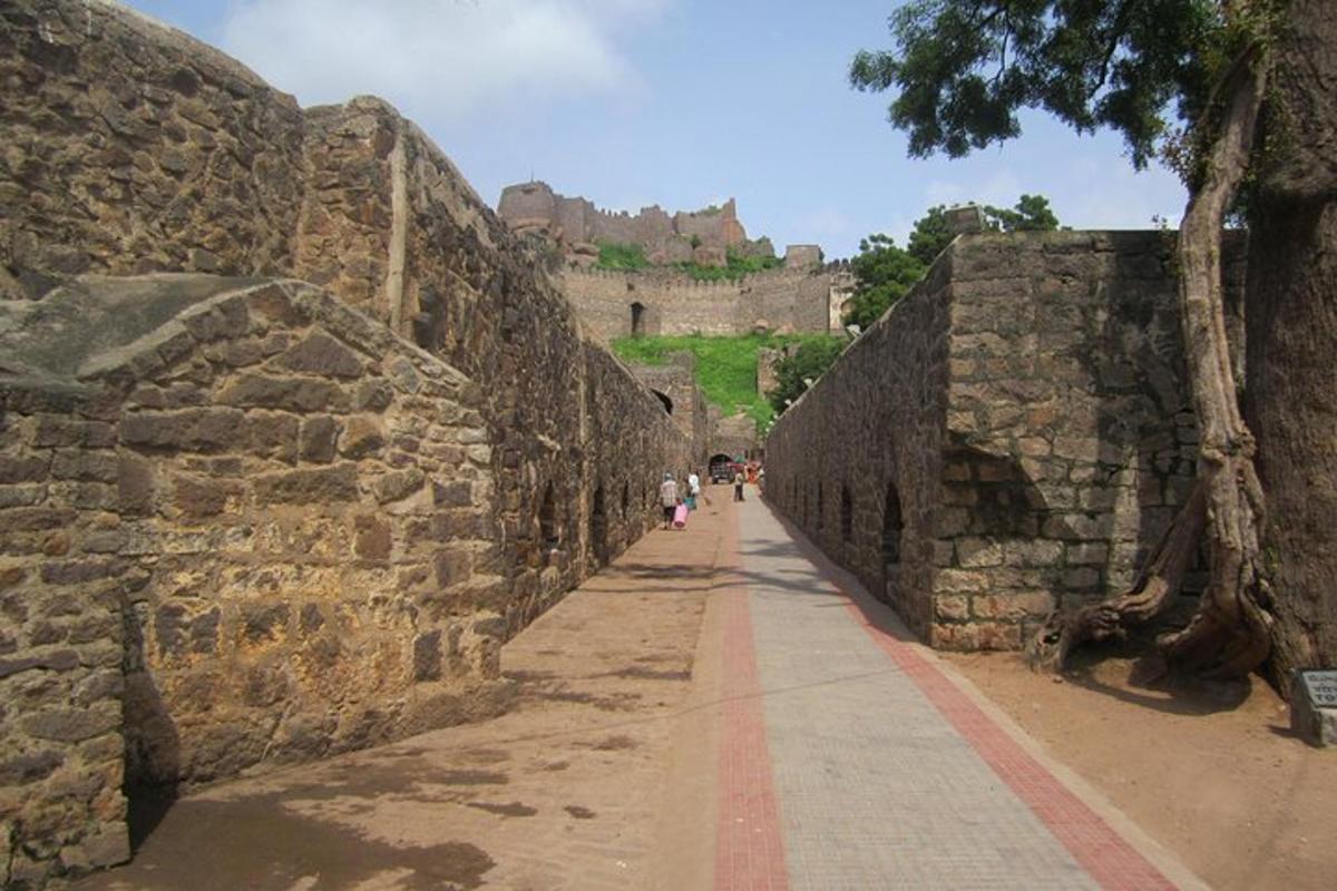an alley with a wall with a castle in the background