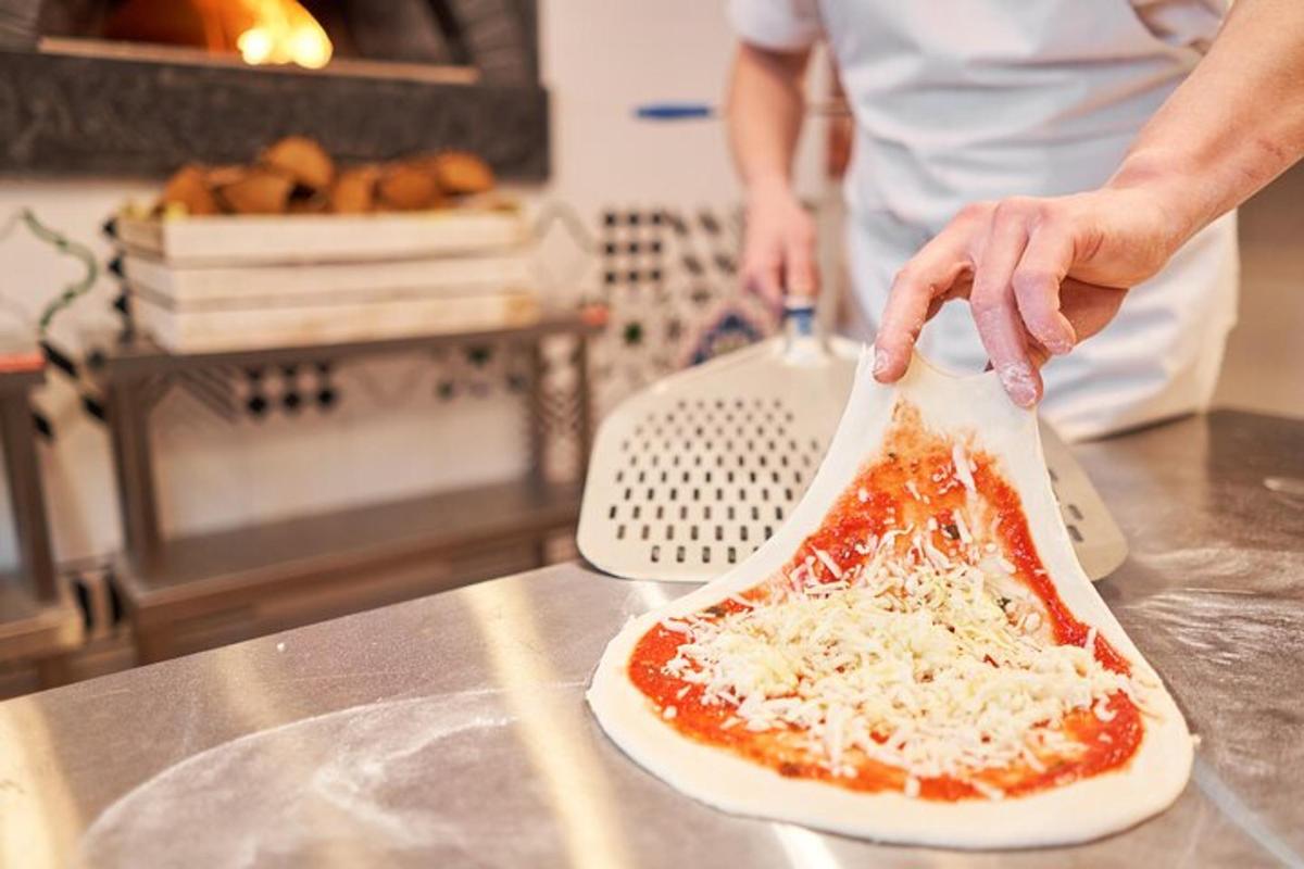 Maður er að útbúa pizzu á borði