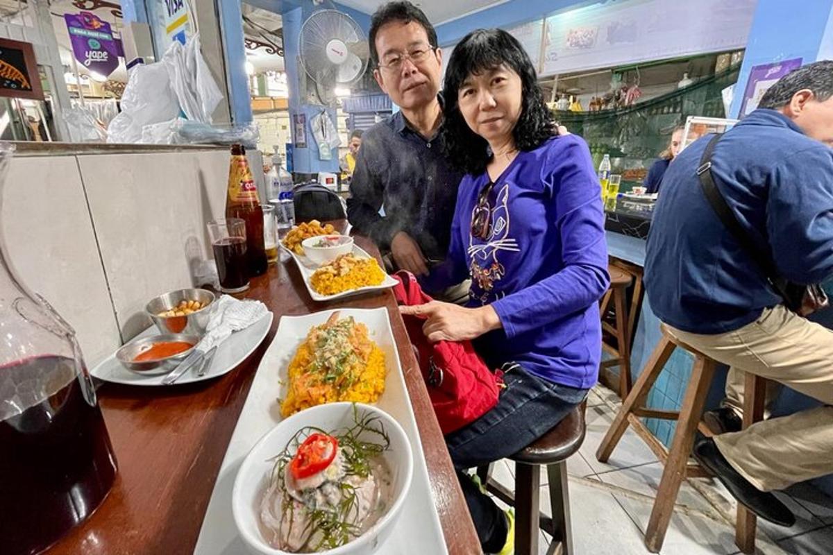 một người đàn ông và một người phụ nữ đang ngồi ở một cái bàn với thức ăn