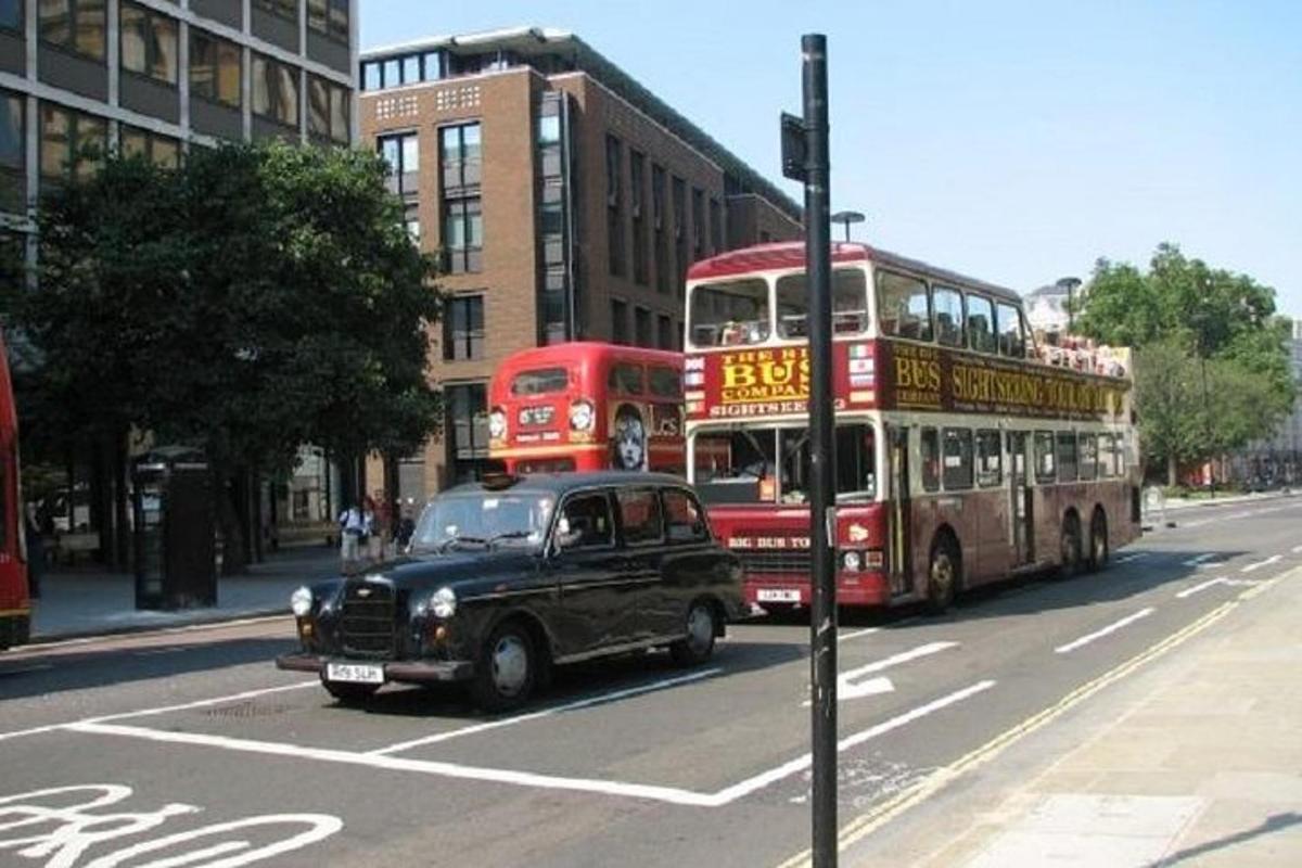 um carro preto e um ônibus de dois andares em uma rua