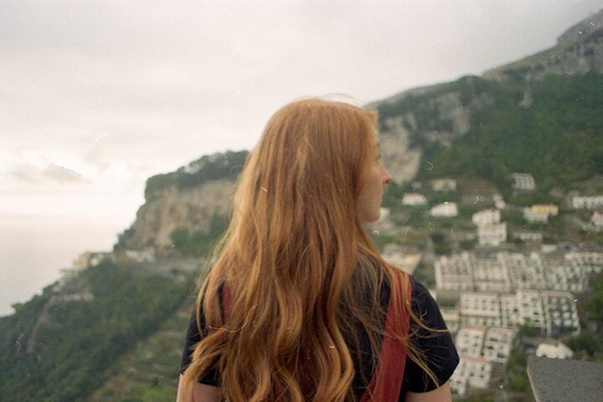 Μια γυναίκα που στέκεται στην κορυφή ενός βουνού κοιτάζοντας τον ωκεανό