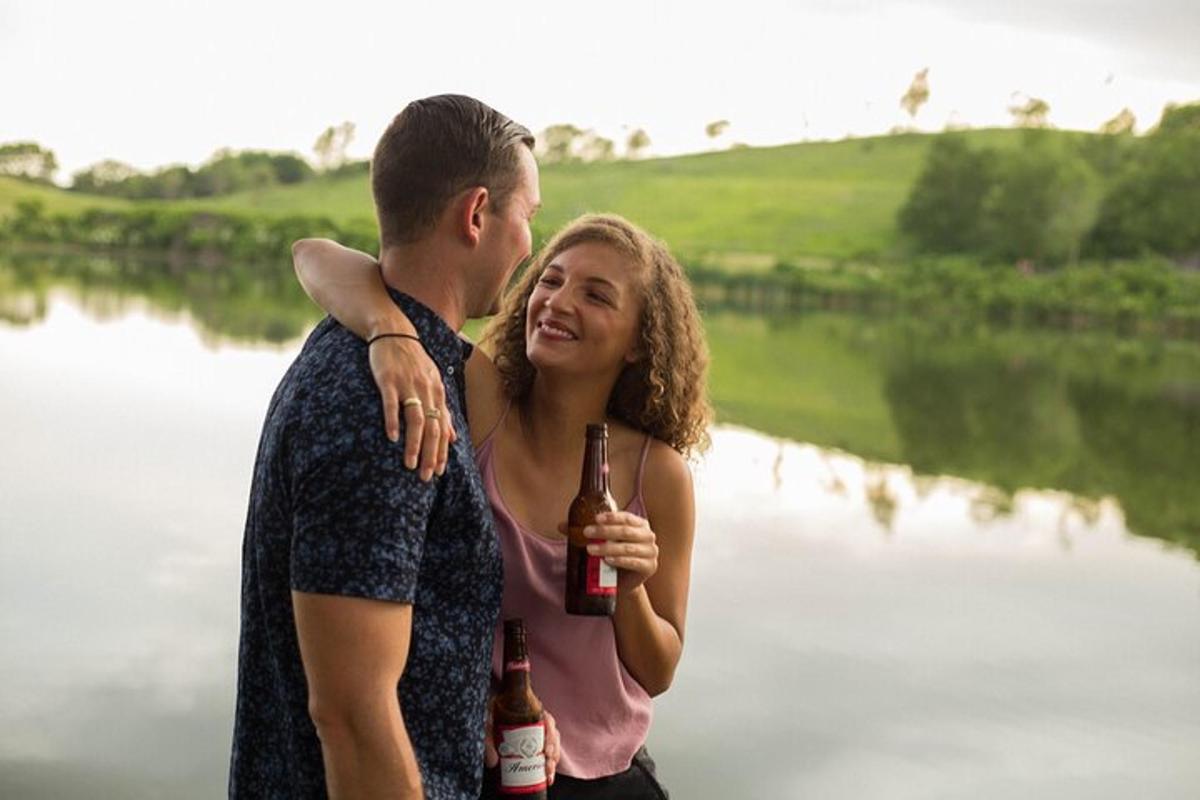 ビール瓶を持って川のそばに立っている男女