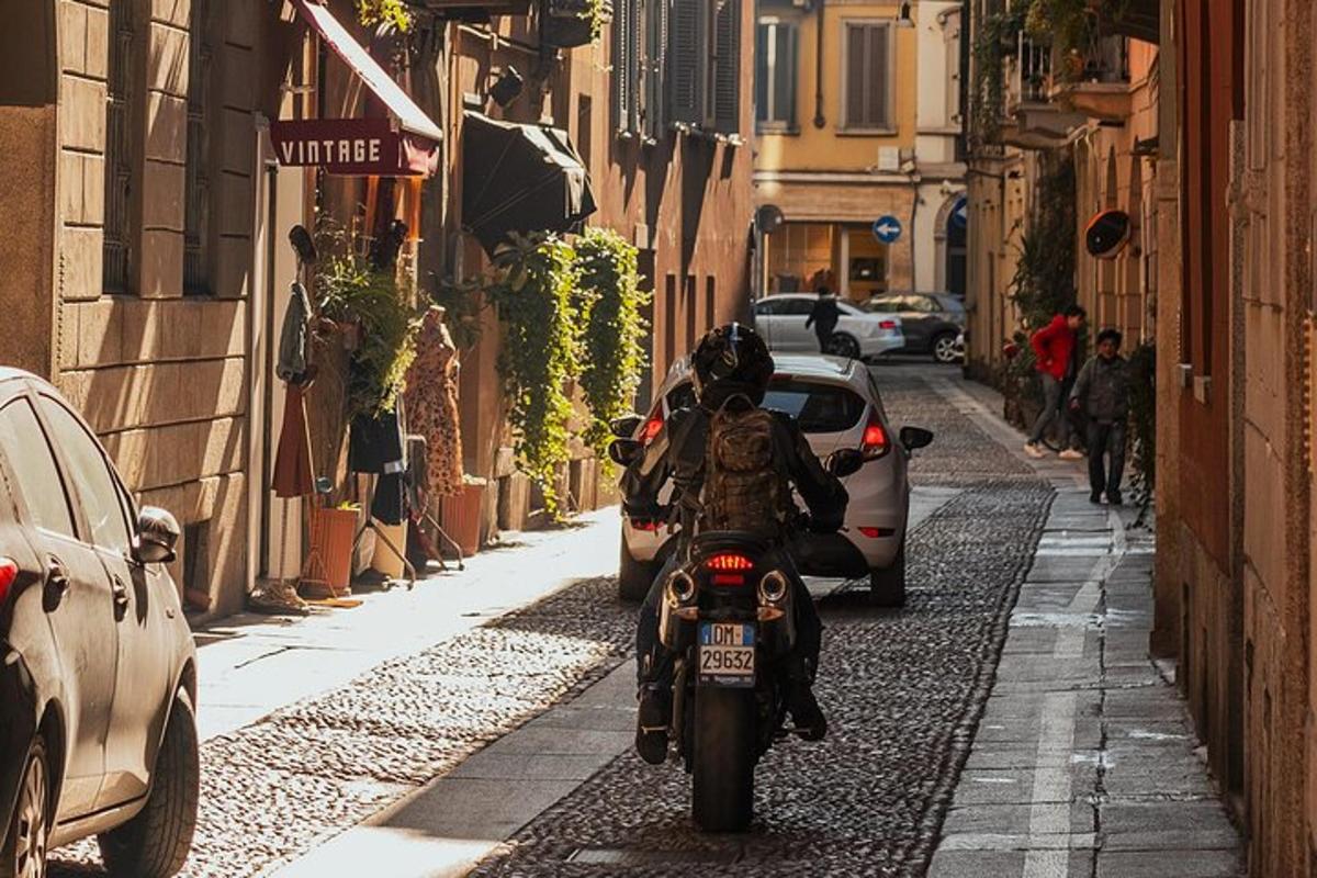 egy személy motorkerékpáron halad egy keskeny utcán