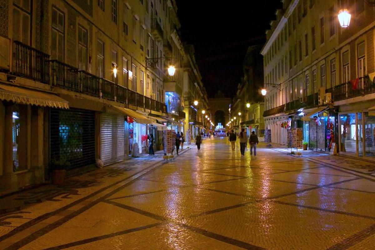 mestna ulica ponoči z ljudmi, ki hodijo po njej