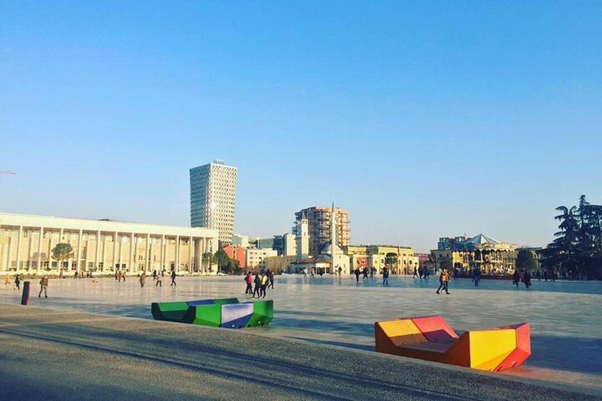 un gruppo di persone che camminano in una piazza con oggetti colorati