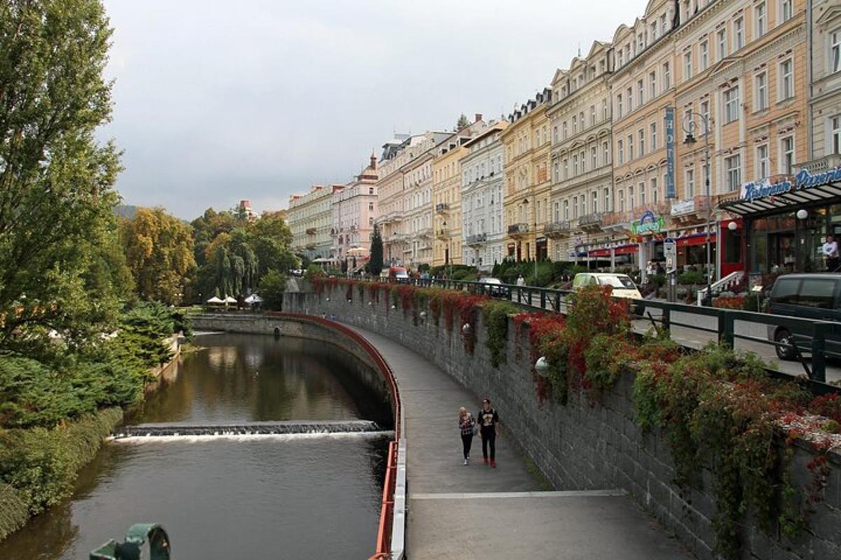 two people walking on a bridge over a river