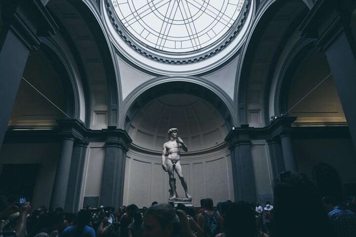 en statue af en mand i et rum med en menneskemængde