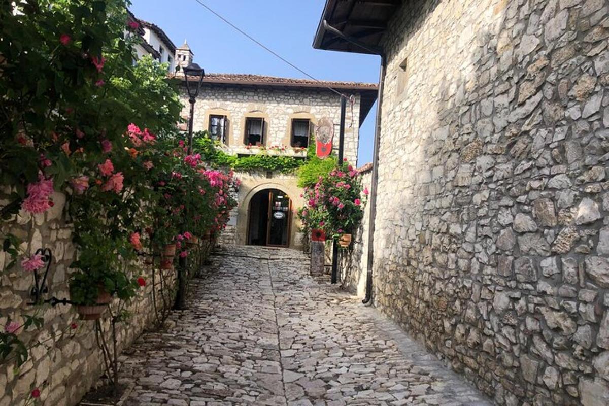 an alley in an old stone building with flowers