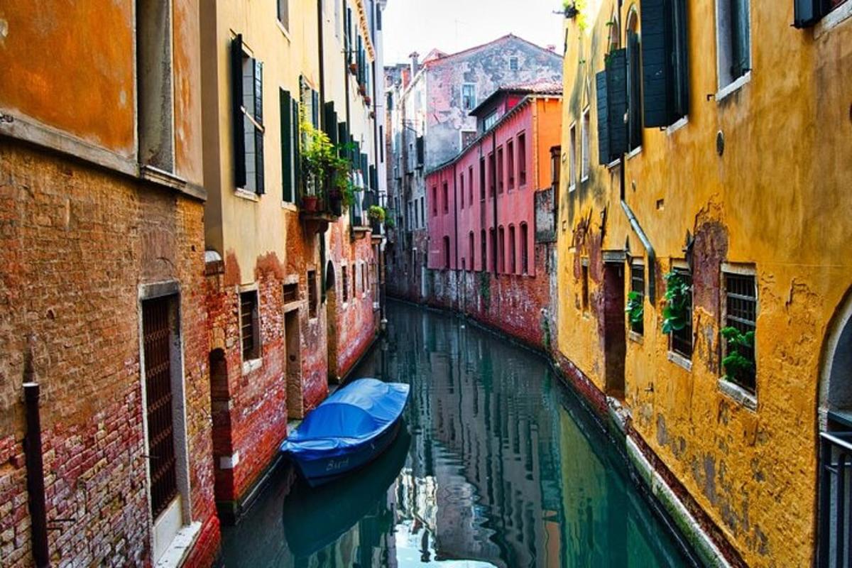 Un canal entre dos edificios con un barco azul en el agua.