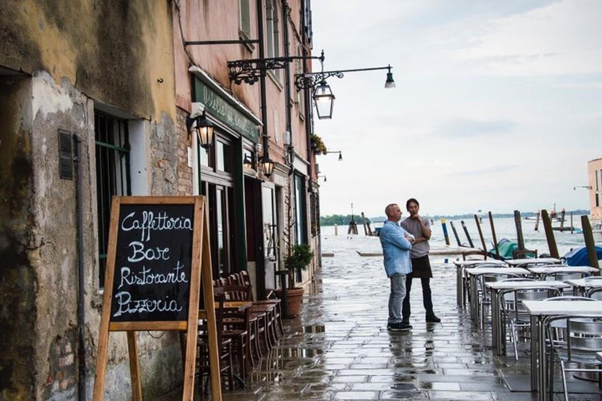 twee mensen staan op straat met tafels en stoelen