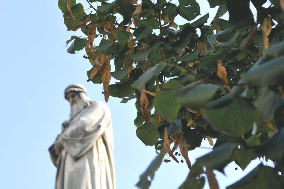 patung berdiri di sebelah pokok dengan daun