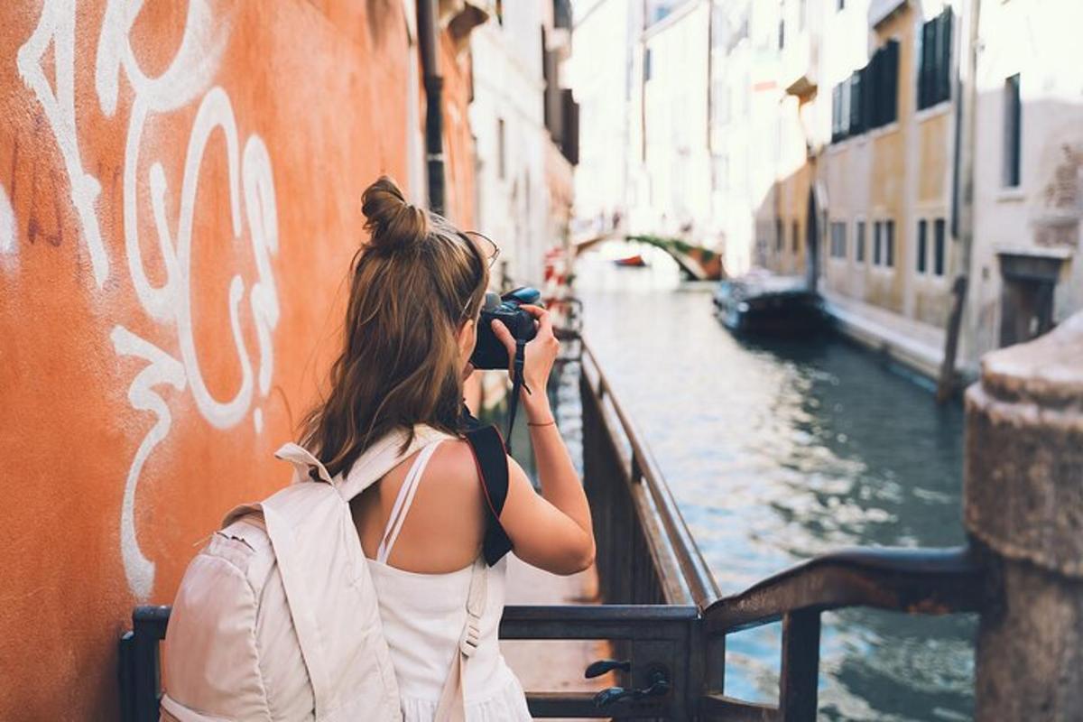 una donna che scatta una foto di un canale con una macchina fotografica