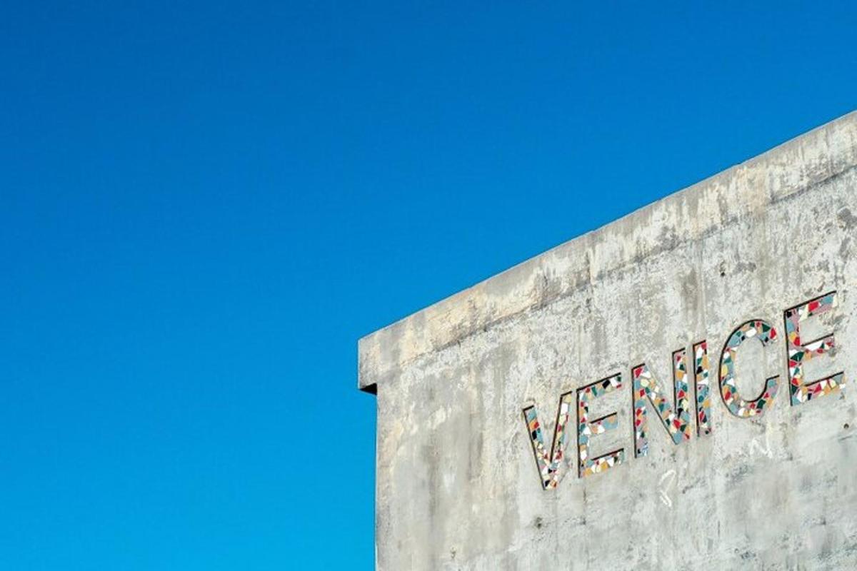un cartello sul lato di un edificio con un cielo azzurro
