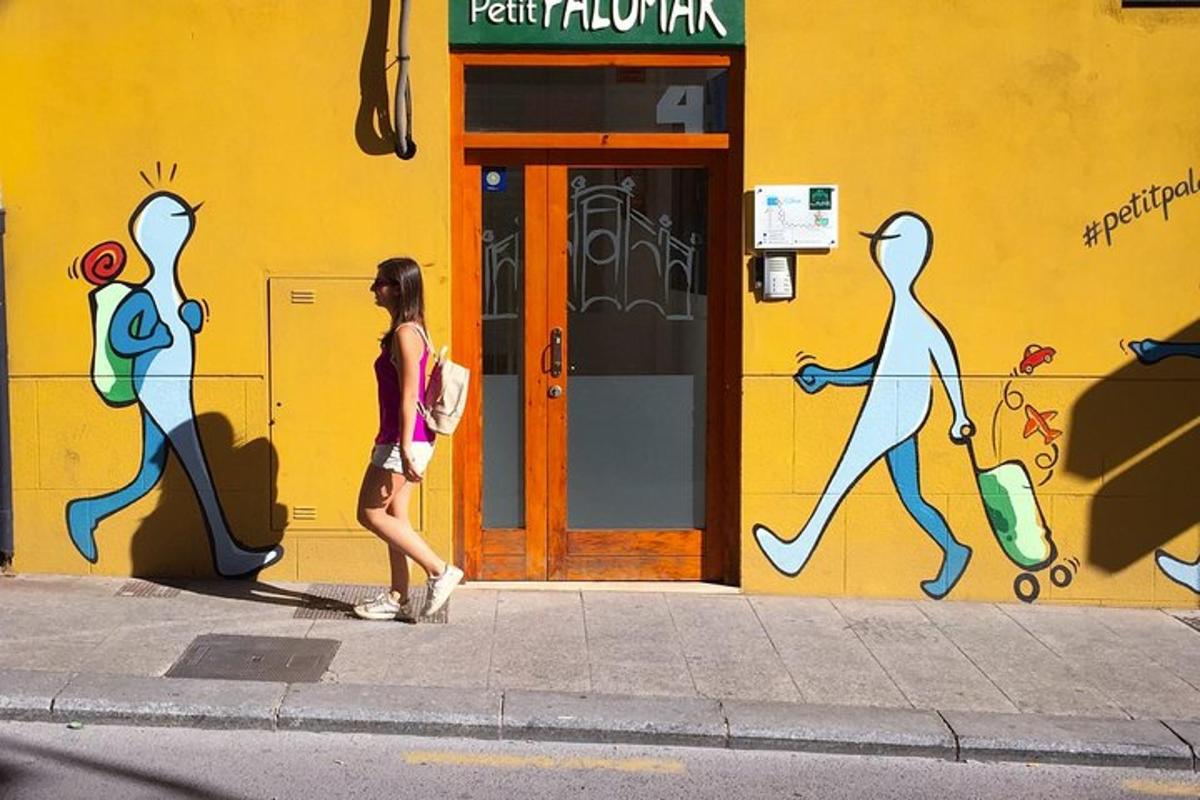 una donna che cammina sul marciapiede davanti a un edificio con graffiti