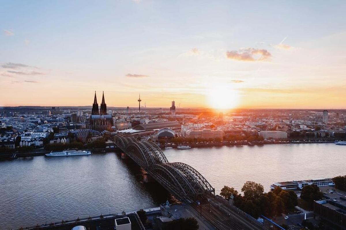 Una puesta de sol sobre una ciudad con un río y un puente.