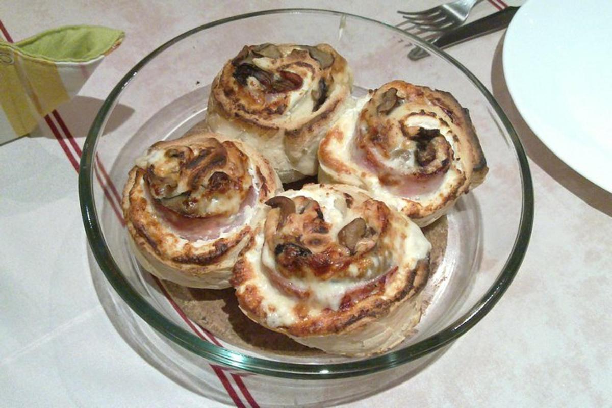 patru produse de patiserie pe o farfurie de sticlă pe o masă