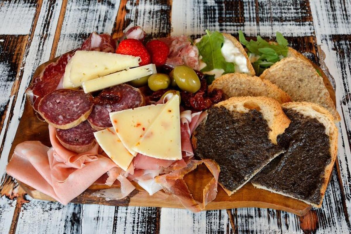 un piatto di cibo con carne, formaggio e frutta