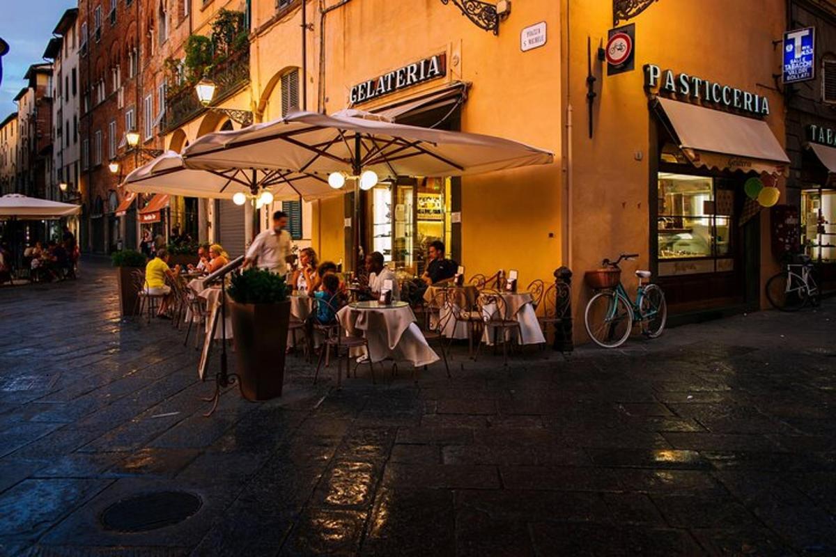 un grup de persones assegudes a taules fora d'un restaurant