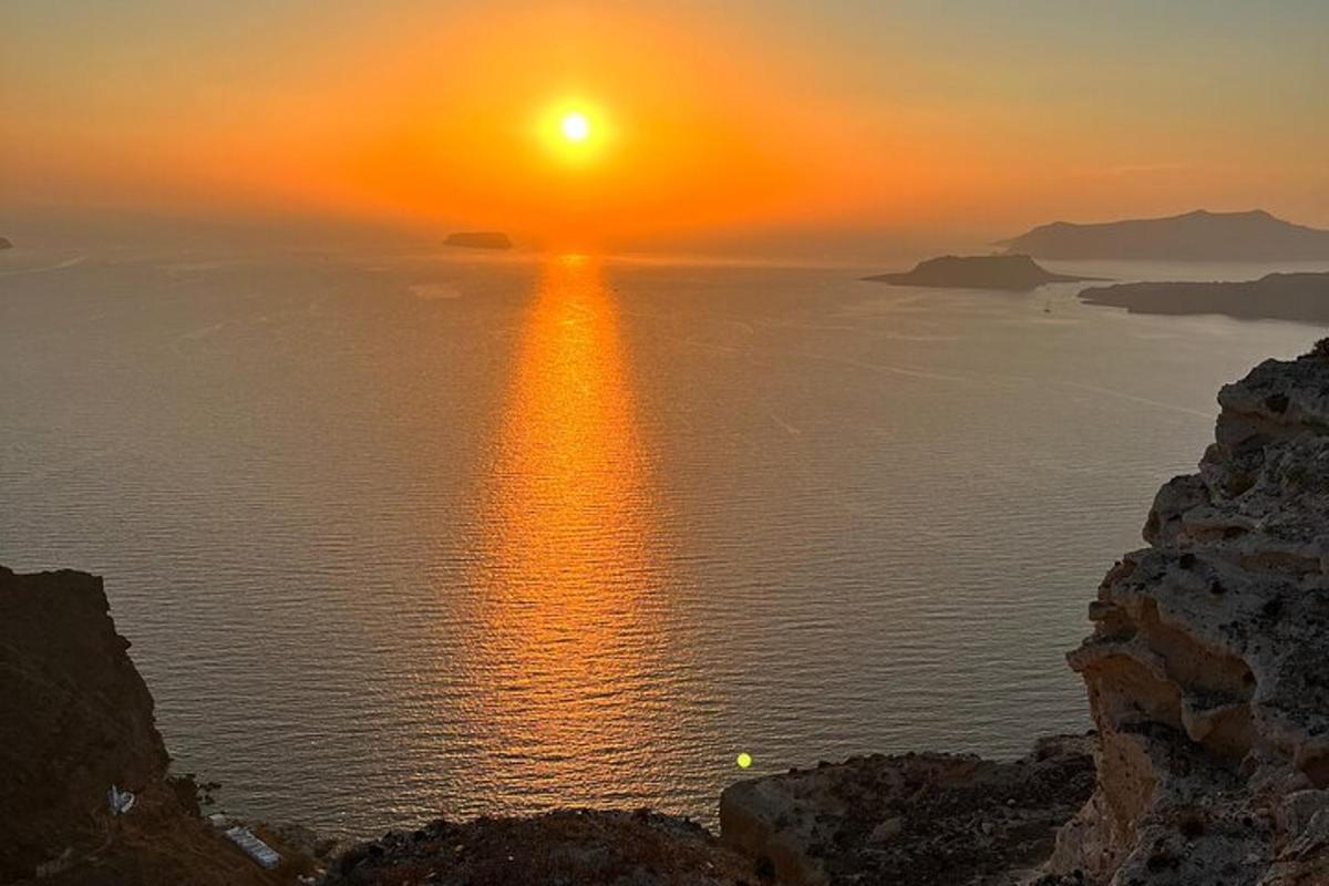 ένα ηλιοβασίλεμα στον ωκεανό με τον ήλιο να δύει πάνω από το νερό