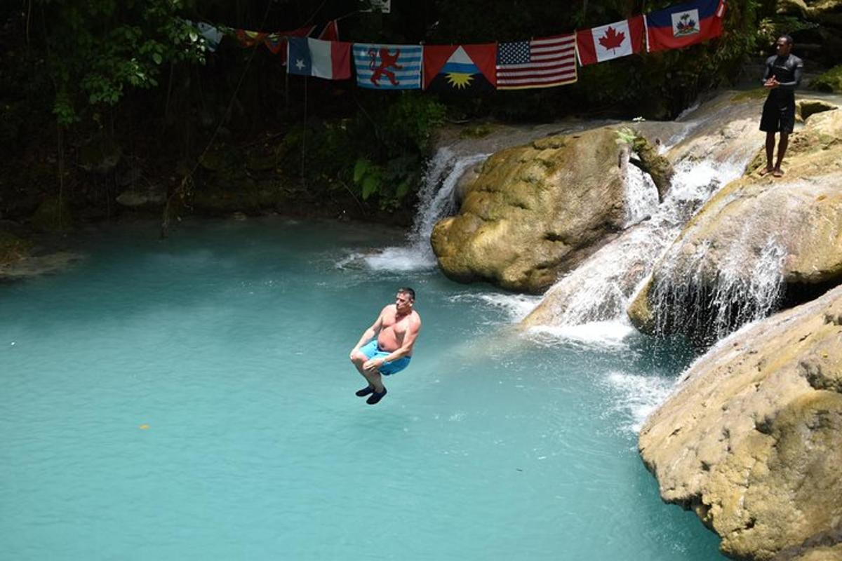 un bărbat care sare într-o piscină cu apă dintr-o cascadă