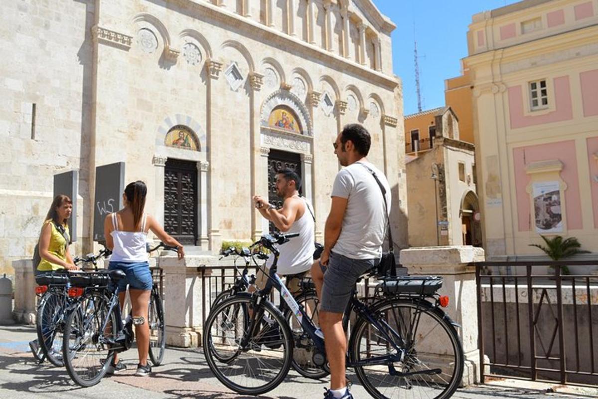 un gruppo di persone in piedi con le biciclette davanti a un edificio