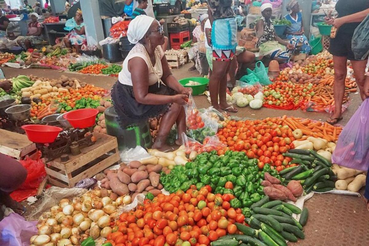 a woman in a market with a bunch of fruits and vegetables