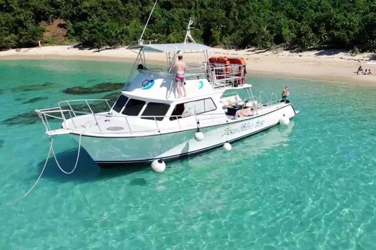 una barca bianca nell'acqua vicino a una spiaggia