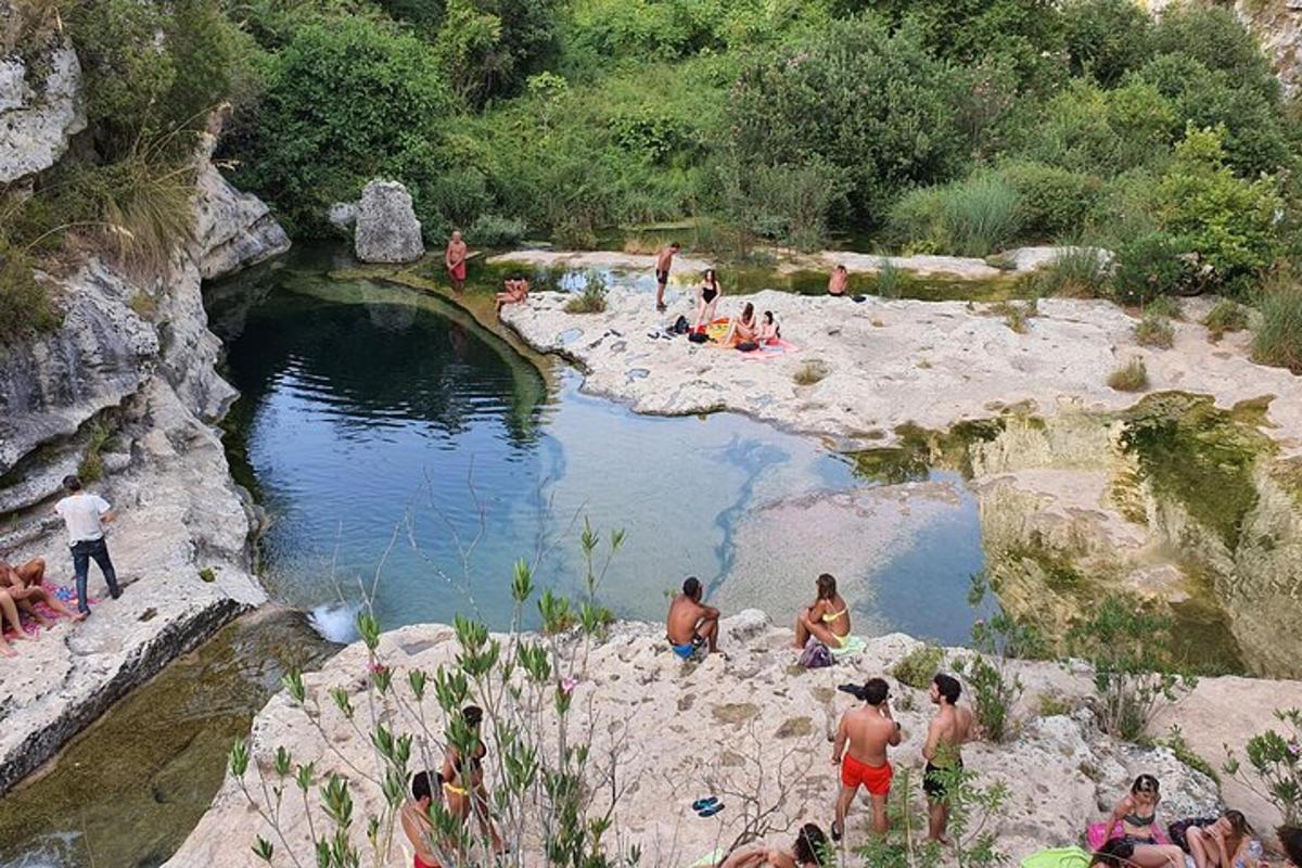 skupina ljudi, ki sedijo okoli bazena z vodo