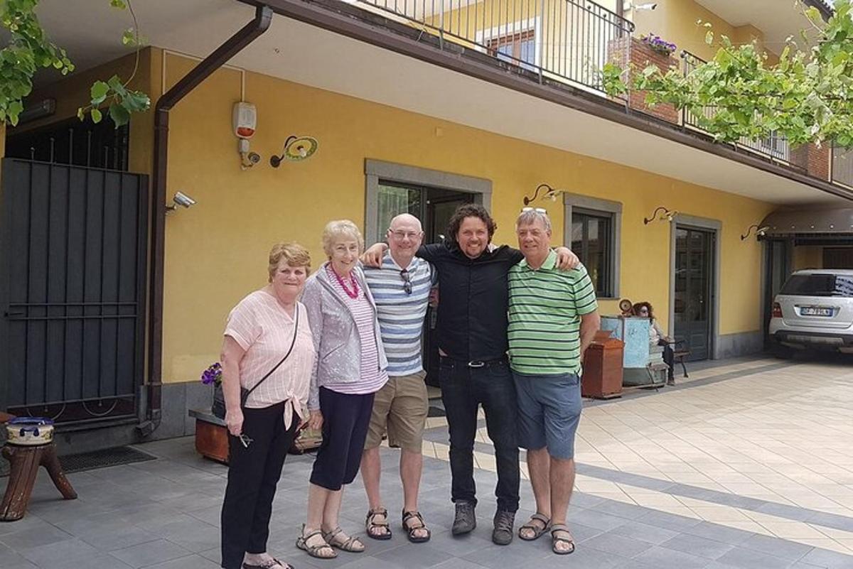 en gruppe mennesker poserer til et billede foran et hus