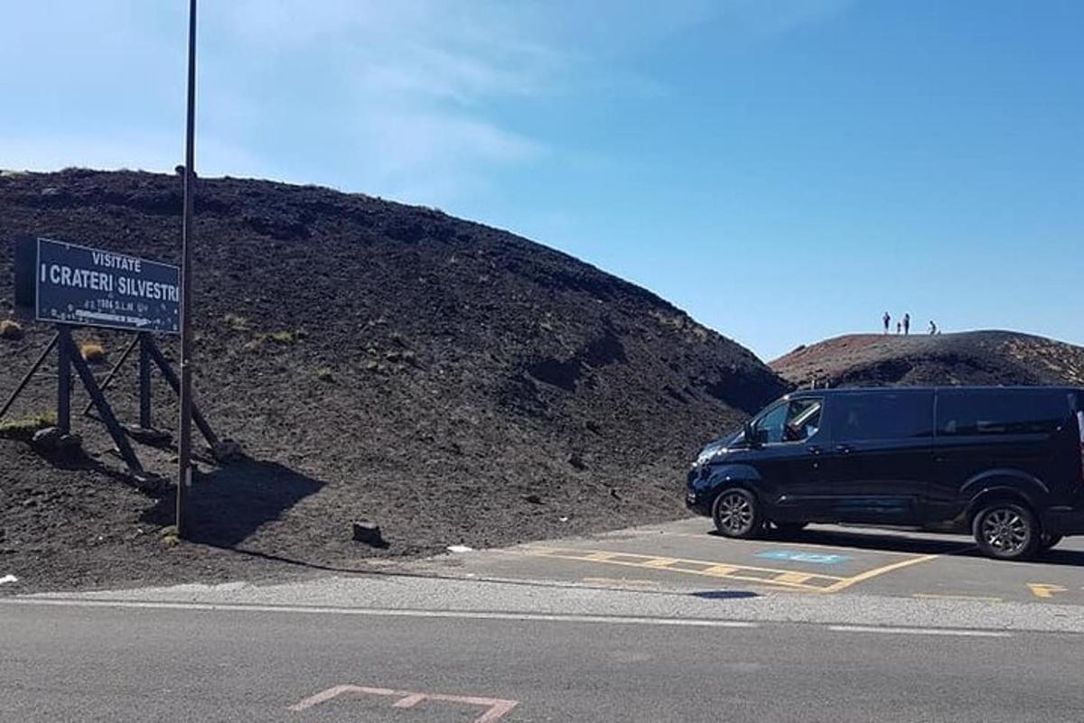 Blár vörubíll lagður við skilti á hæð