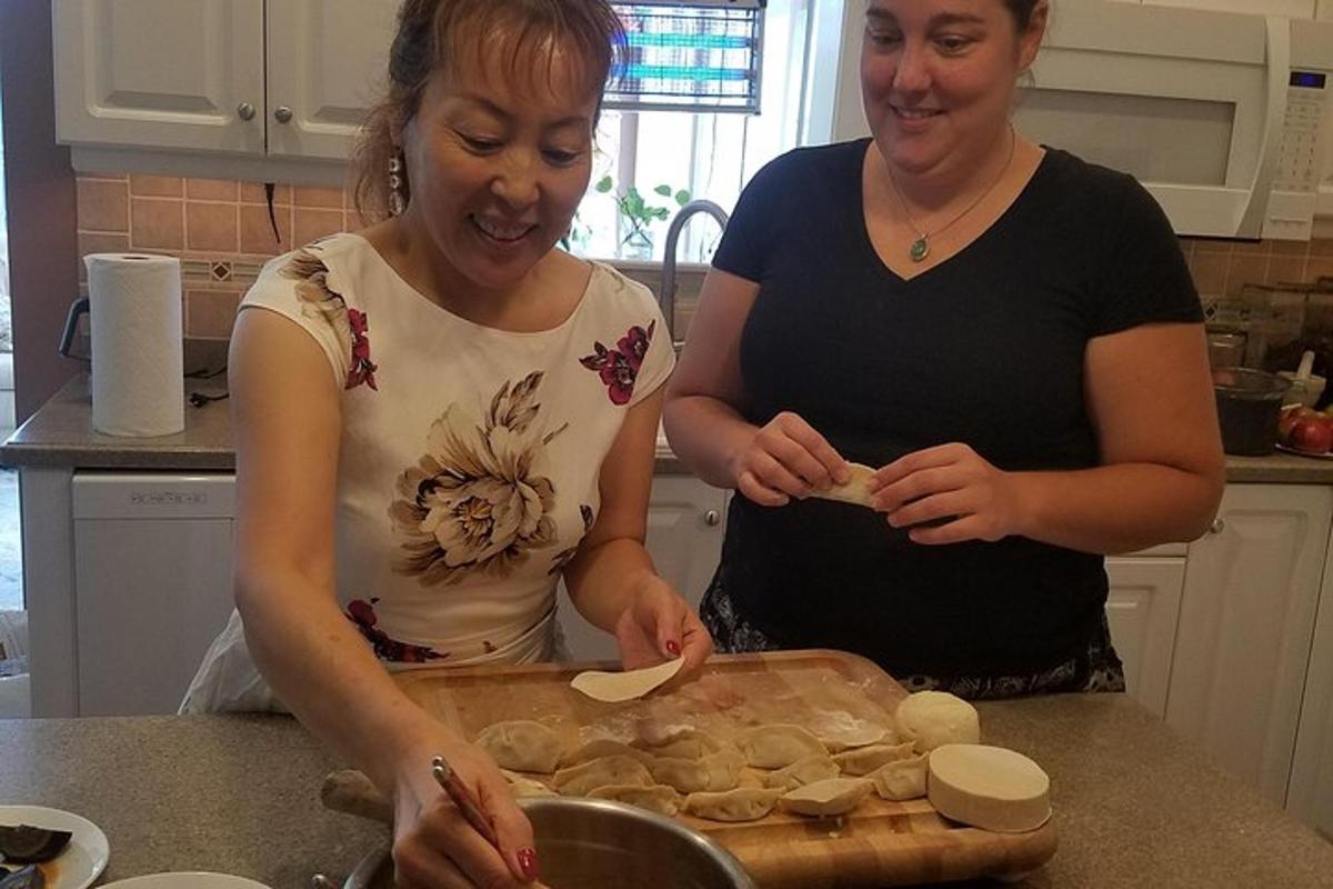 two women standing in a kitchen preparing food