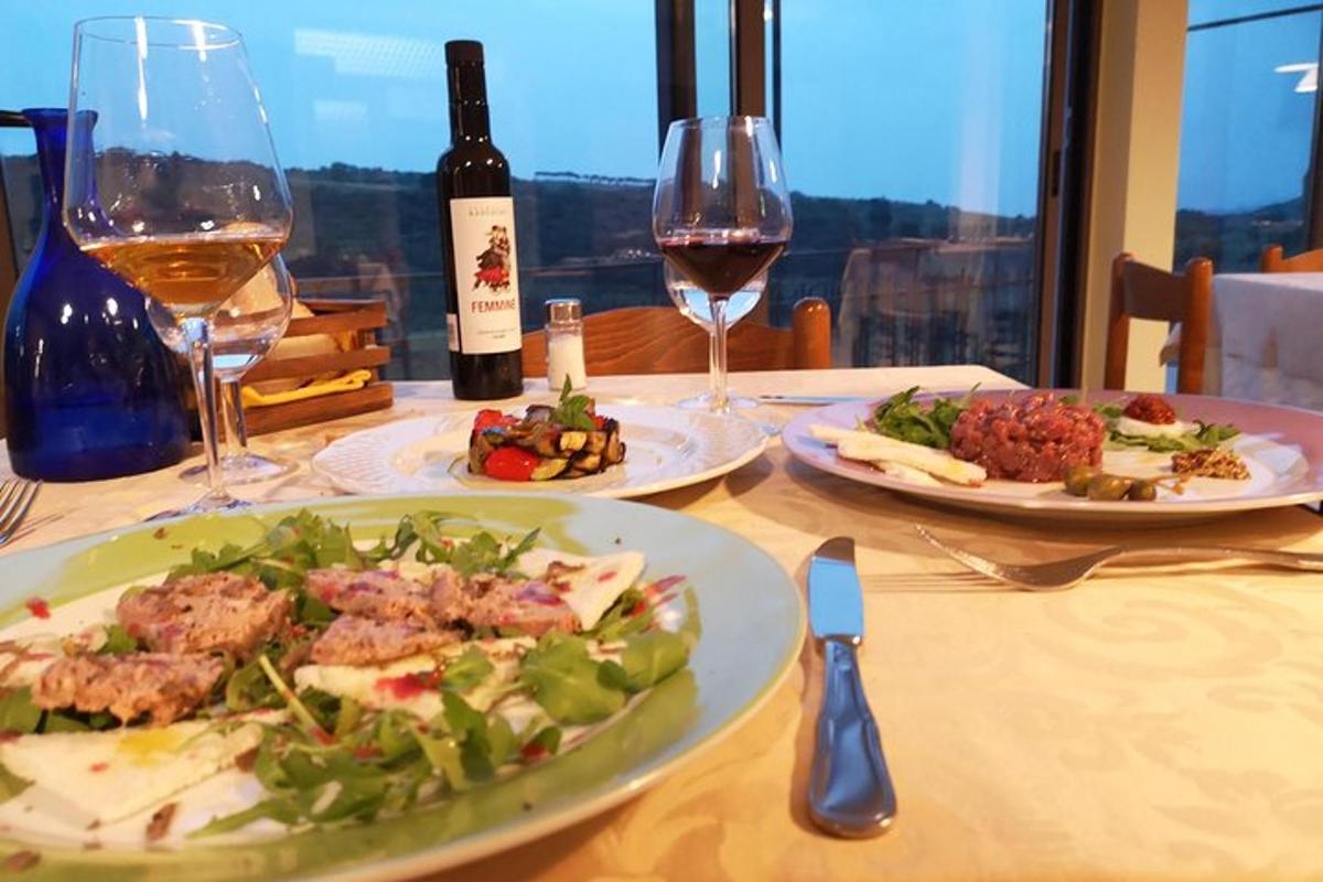 a table with two plates of food and wine glasses